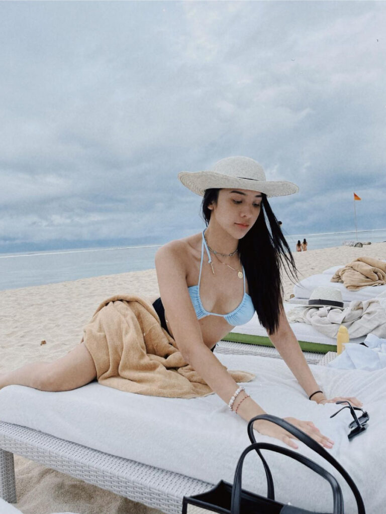 anya geraldine seksi pakai bikini biru topi rajut manis di pantai pasir putih