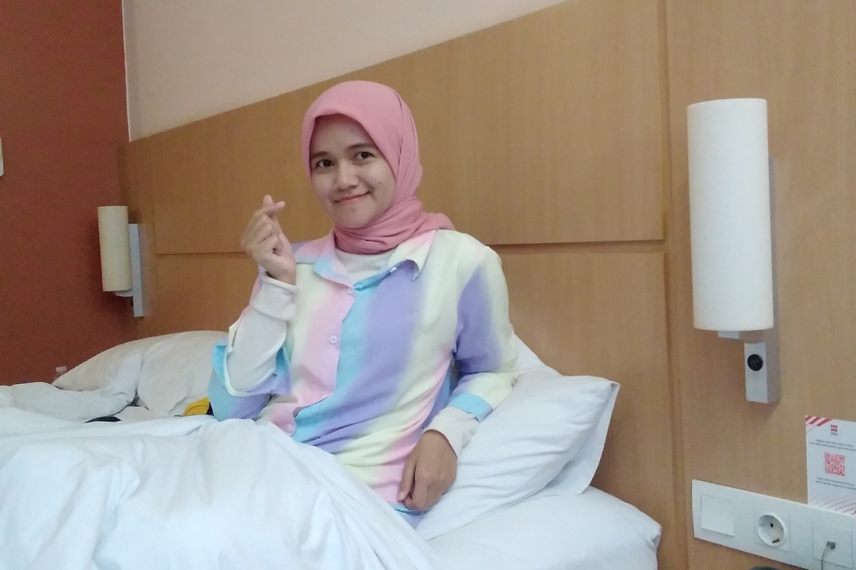 Cewek Hijab Pink Selfie cantik di ranjang hotel