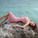 Foto Seksi Berliana Lovell Pose Menggoda tidur du atas batu di pinggir pantai